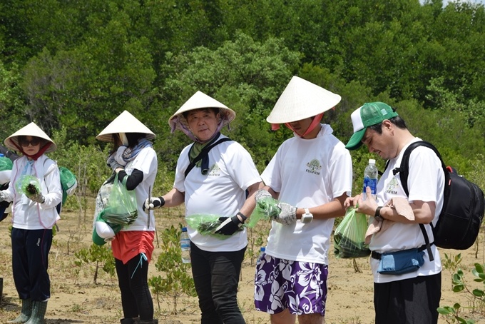 Khách Nhật Bản đội nón, trồng cây ở ngoại thành Sài Gòn